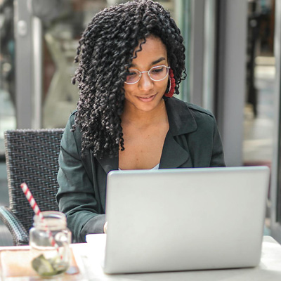 Frau sitzt im Cafe am Laptop