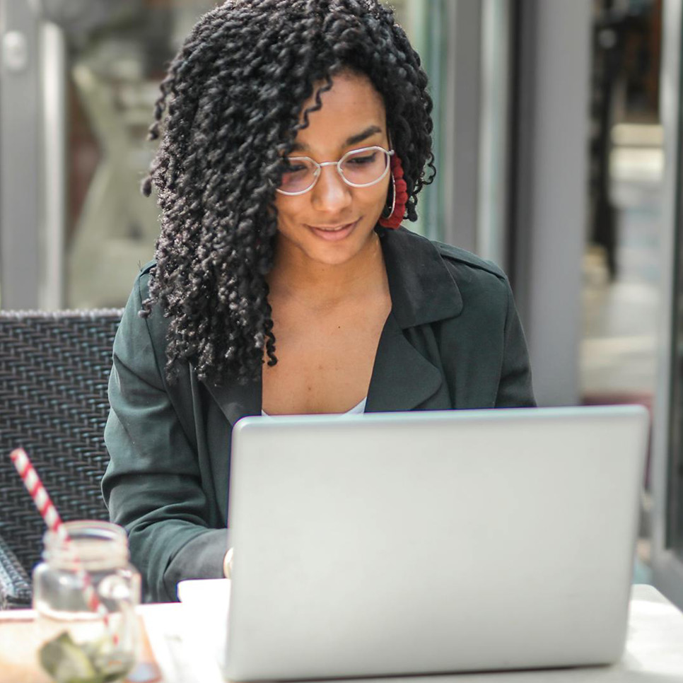 Frau sitzt im Cafe am Laptop